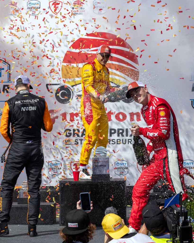 Alex Palou celebrates on the podium after winning the Firestone Grand Prix of St Petersburg as drivers spray champagne