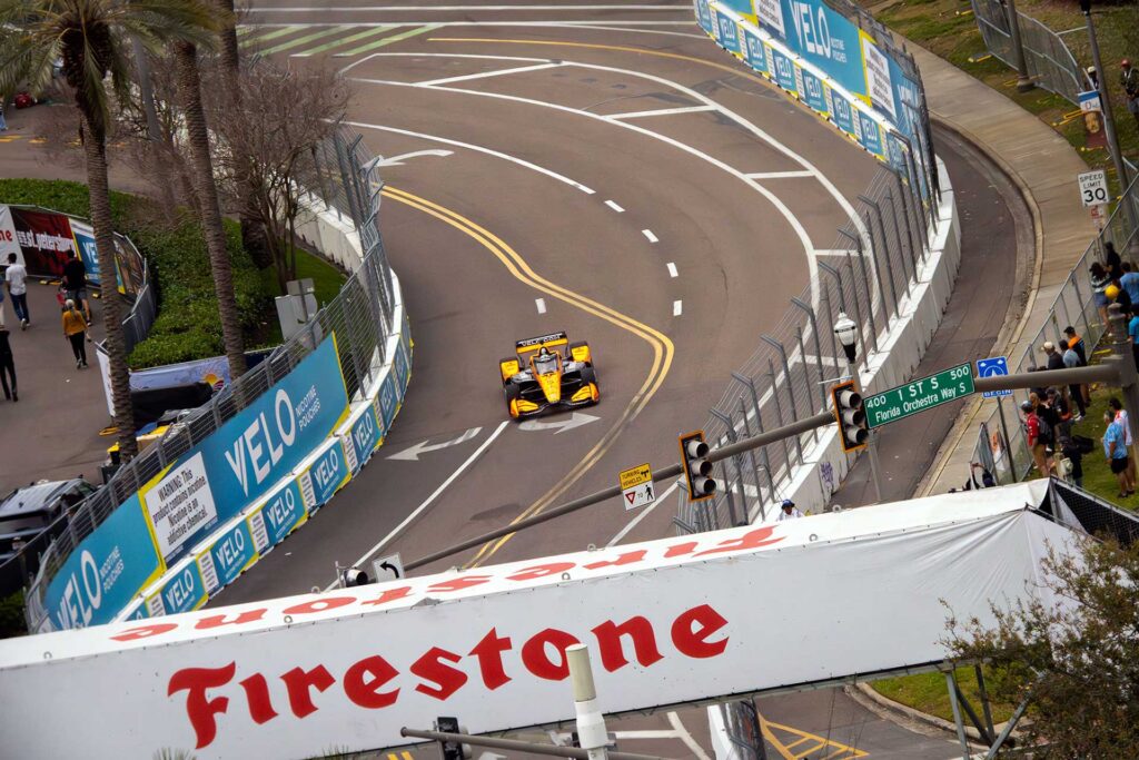 NTT INDYCAR Series car racing through a downtown St. Petersburg street circuit corner during the Firestone Grand Prix of St. Petersburg